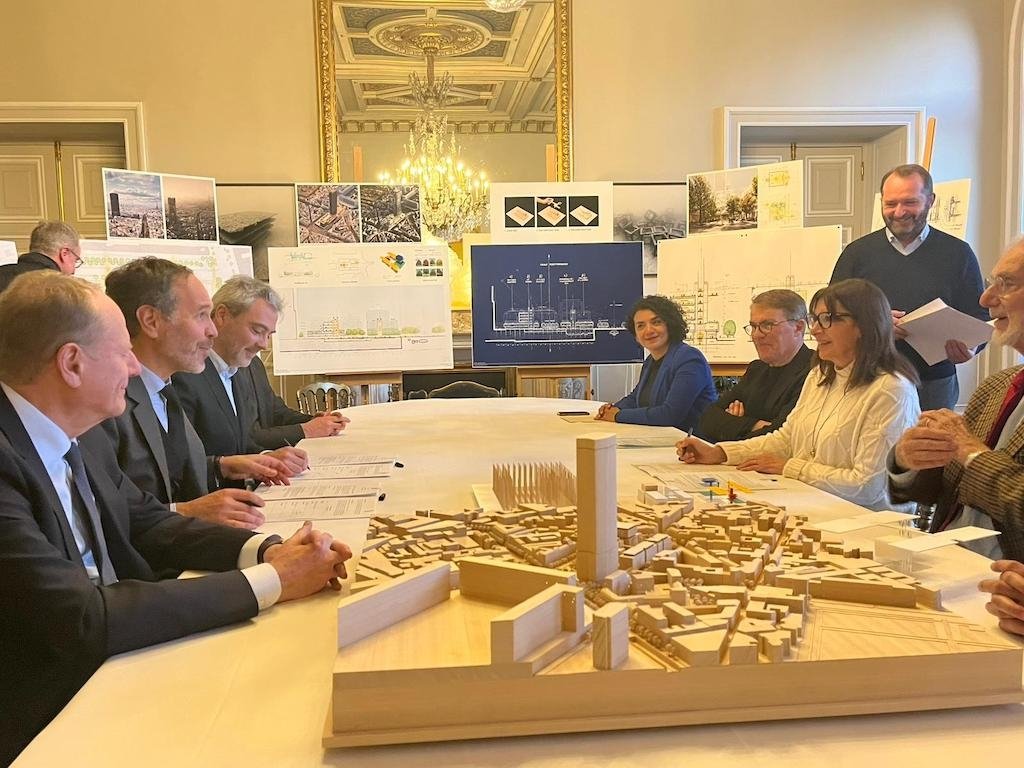 Frédéric Lemos, représentant « à titre amical » de NRS, est assis face à Anne Hidalgo, maire de Paris, lors de la signature du protocole. Frédéric Lemos, représentant « à titre amical » de NRS, est assis face à Anne Hidalgo, maire de Paris, lors de la signature du protocole.